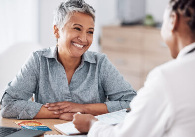 Paperwork, doctor or consulting a happy patient in meeting talking in hospital for history or healthcare record. Smile, medical or nurse with mature woman speaking of test results, update or document.