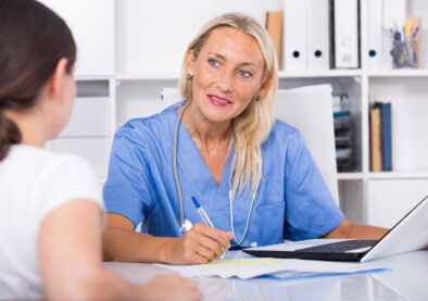 Portrait of mature female doctor listening to patient complaints at clinic