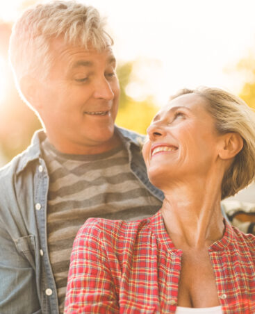 Happy mature couple hugging in the city on a sunny day