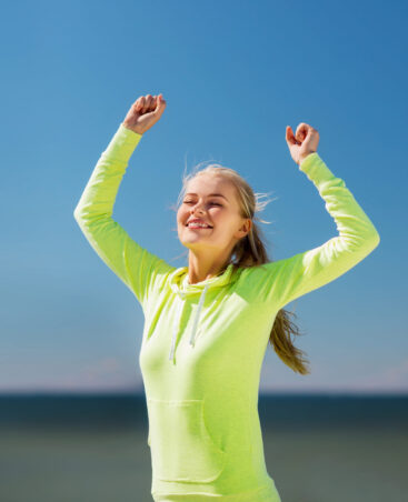 sport and lifestyle concept - woman runner celebrating victory