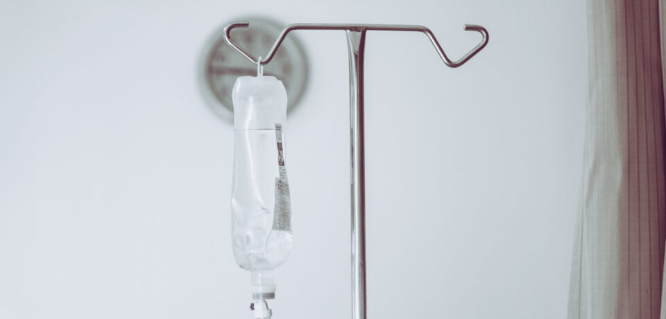 IV bag hanging on a metal pole in the hospital room